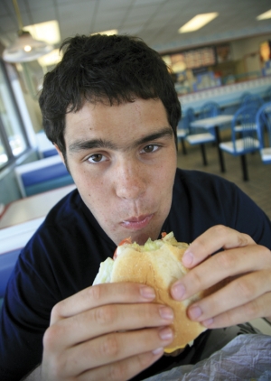 garçon mangeant un hamburger